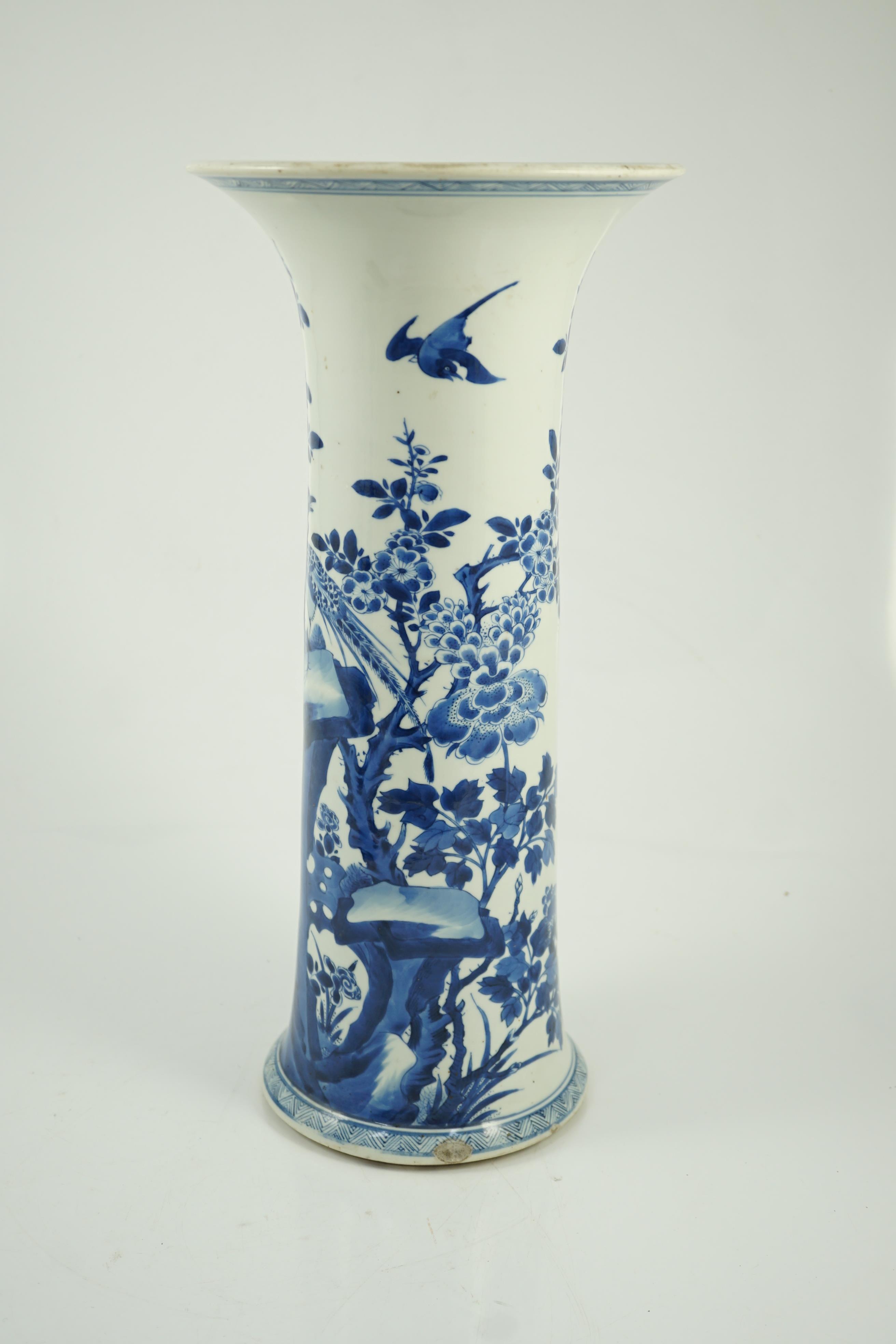 A tall Chinese blue and white ‘pheasants and rocks’ beaker vase, gu, Kangxi period, minor faults